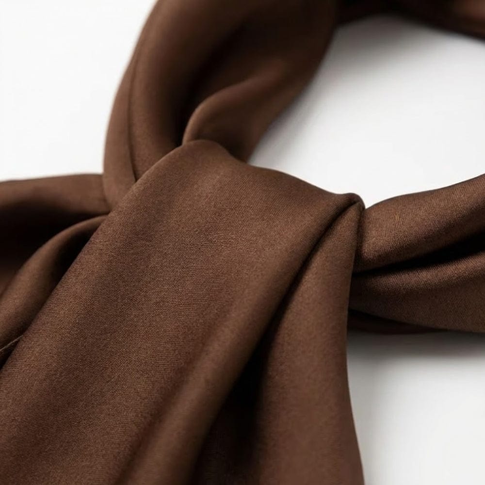 Foulard en satin marron aux teintes naturelles, noué avec élégance pour une allure sophistiquée