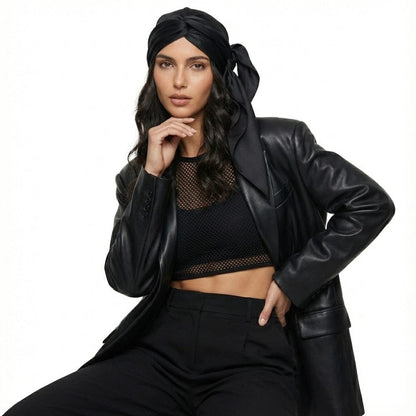 Foulard noir en satin noué sur une femme, associé à un blazer en cuir pour une allure moderne et élégante