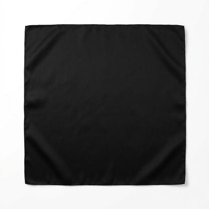 Foulard carré noir en satin, au toucher lisse, posé sur un fond clair, évoquant élégance et modernité