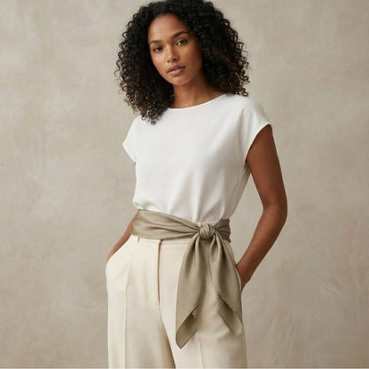 Foulard en satin noué autour de la taille, couleur beige, porté par une femme avec un haut blanc