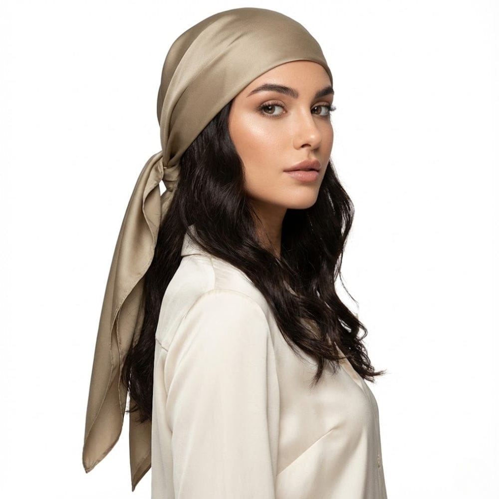 Foulard en satin beige noué sur les cheveux, porté par une femme avec une blouse blanche