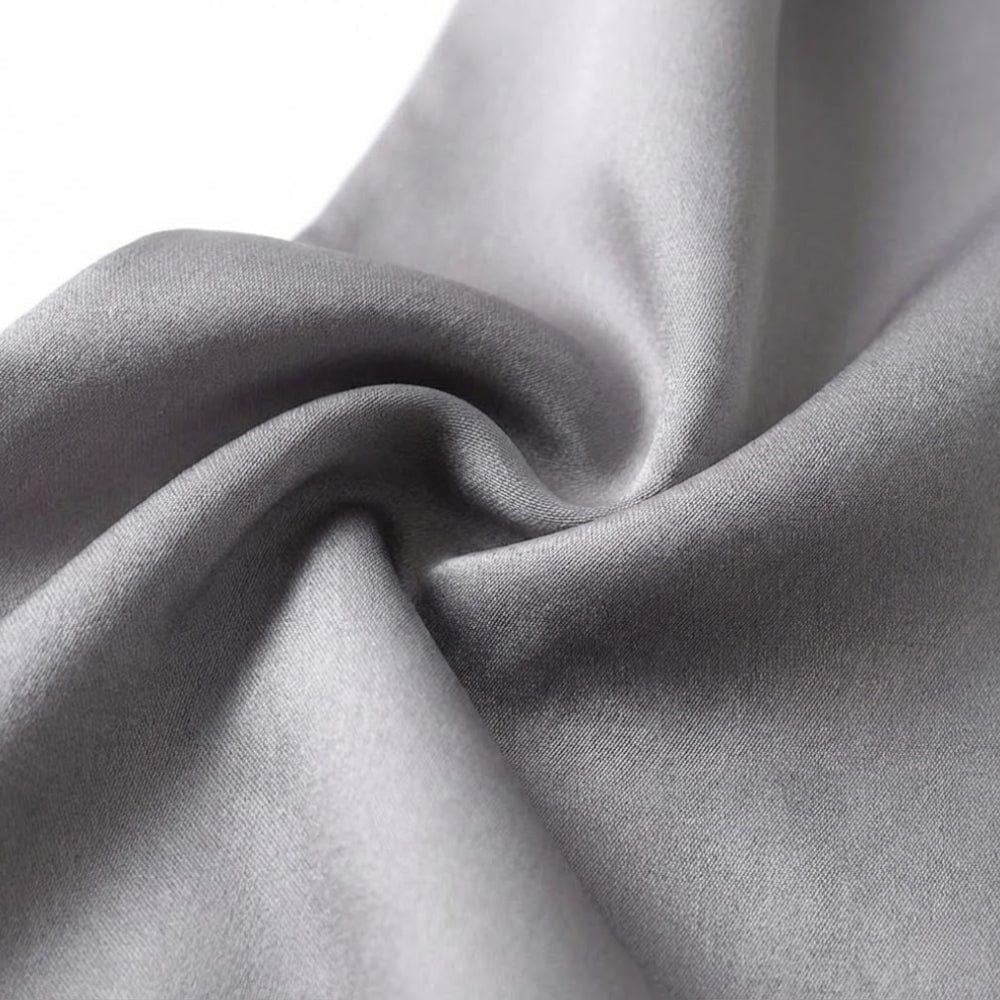 Foulard en soie gris, au toucher doux et élégant, drapé avec des plis délicats sur fond blanc