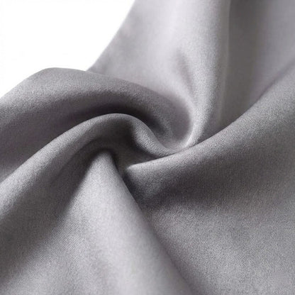 Foulard en soie gris, au toucher doux et élégant, drapé avec des plis délicats sur fond blanc