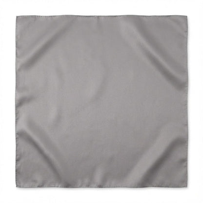 Foulard carré en soie de couleur grise, au fini lisse et élégant, posé sur une surface neutre