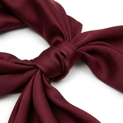 Foulard en satin rouge noué, offrant une élégance intemporelle avec un éclat raffiné et une texture douce