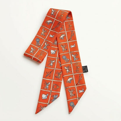 Foulard en satin orange avec motifs graphiques colorés, idéal pour accessoiriser un sac à main