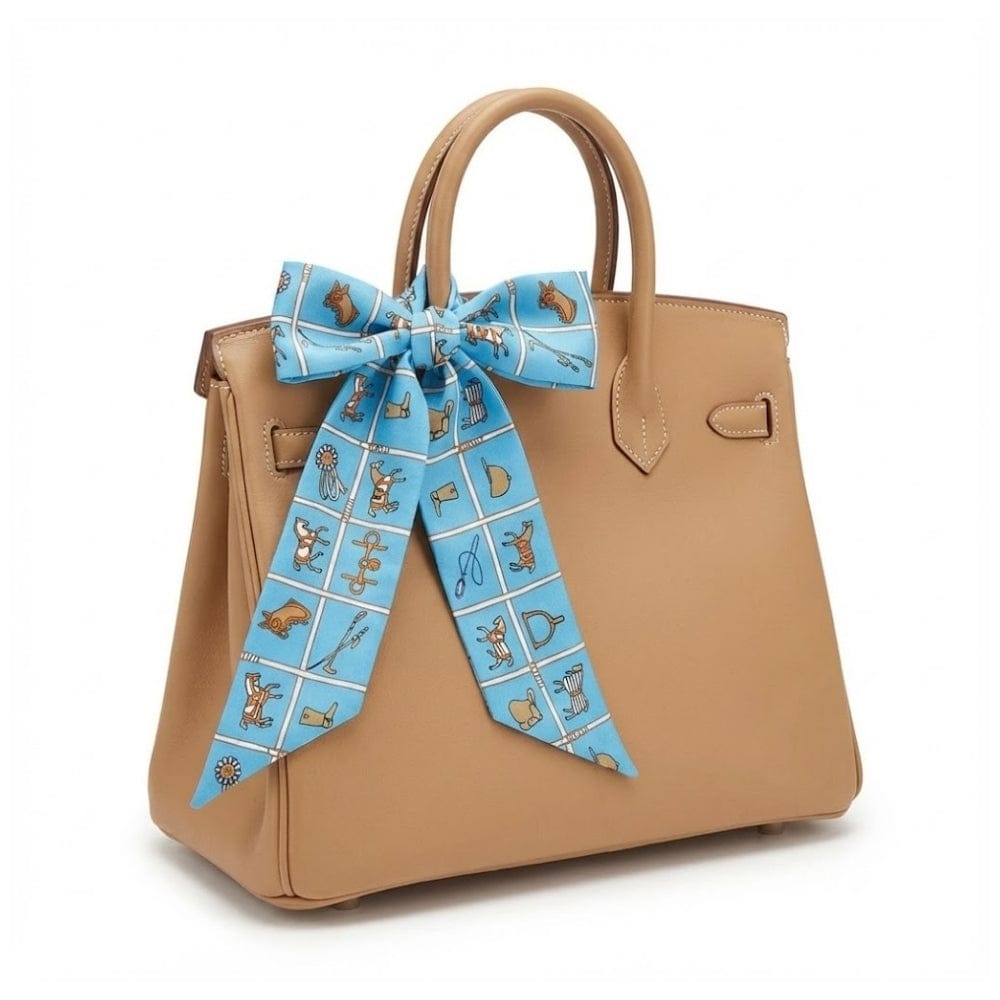 Foulard en soie bleu à motifs colorés noué sur un sac à main beige, ajoutant une touche élégante