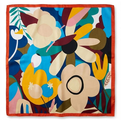 Foulard carré en satin aux motifs floraux colorés, avec une bordure orange, posé sur une surface plane