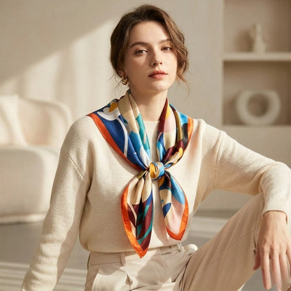 Foulard en satin aux motifs colorés, noué autour du cou d'une femme dans un décor moderne et lumineux