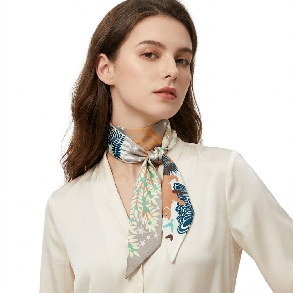 Foulard en satin aux motifs floraux colorés, noué autour du cou d'une femme en blouse claire