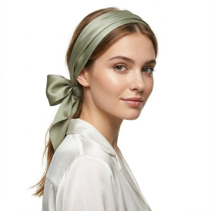 Foulard en soie vert noué avec un élégant nœud, porté par une femme au teint lumineux